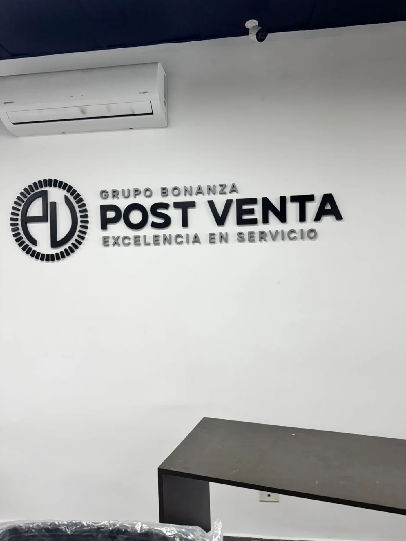 Logotipo corpóreo de Grupo Bonanza Post Venta en pared blanca
