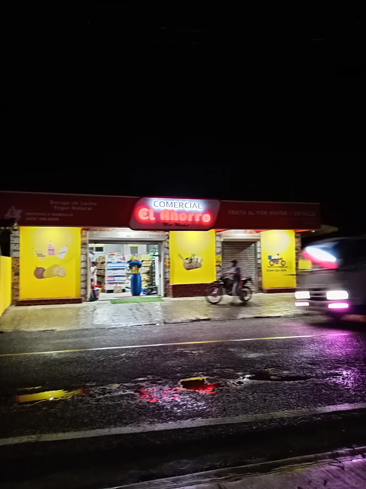Fachada iluminada de Comercial El Ahorro de noche