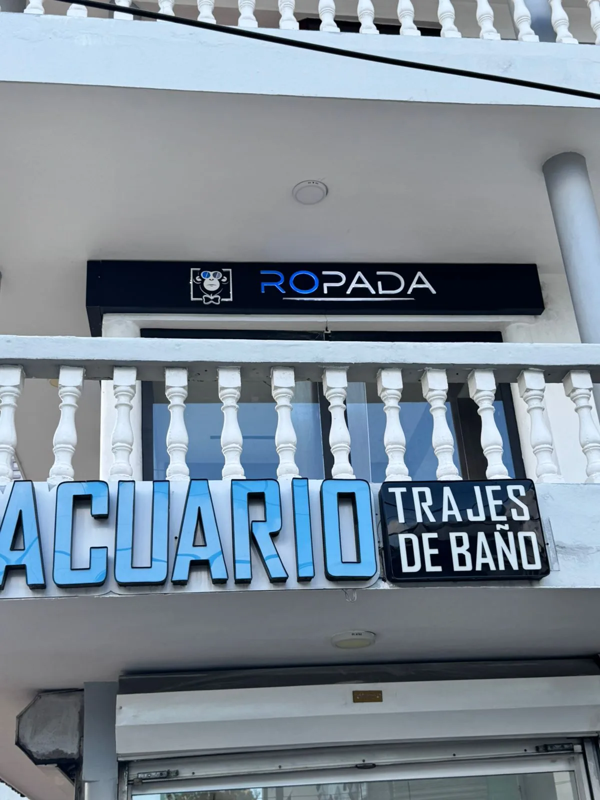 Letrero de Ropada sobre el rótulo de Acuario Trajes de Baño